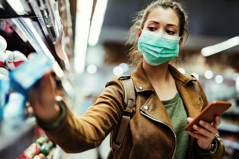 Lady shopping in a supermarket with a protective face mask on, adhering to Covid19 rules